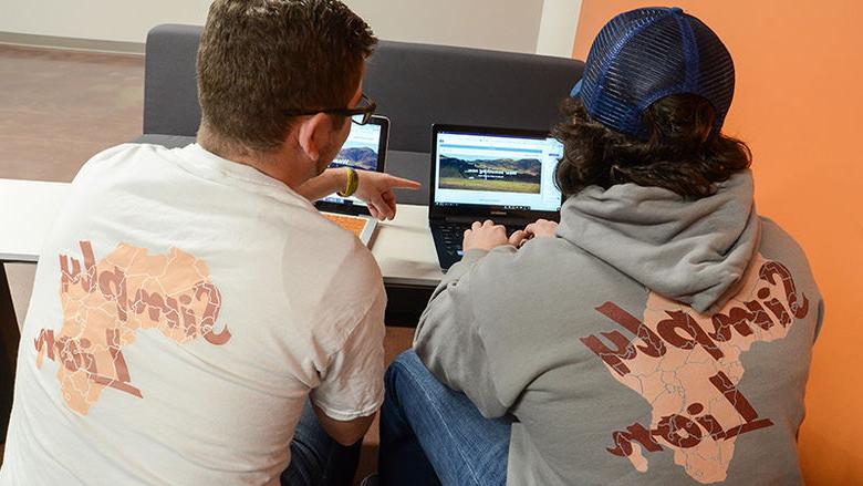 Logan McHale and Bill Butterfield working on their website and sporting their Simply Lion wear