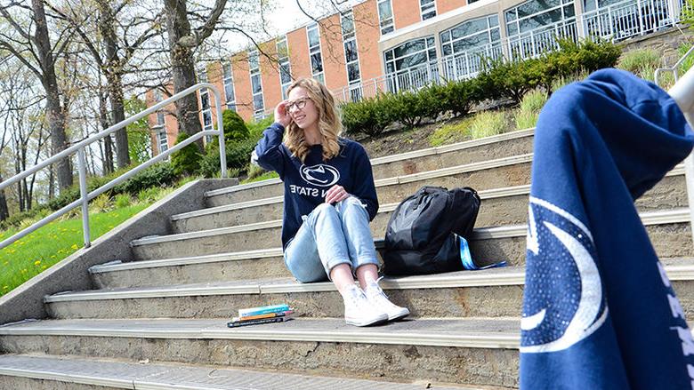 Gabrielle Davidson sits on the steps outside Oak Hall at Penn State Altoona