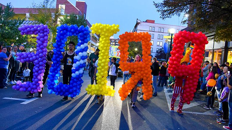 Students hold up balloons spelling Pride at the Penn State Altoona Pride Parade