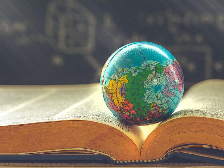 A small globe sitting on top of a book